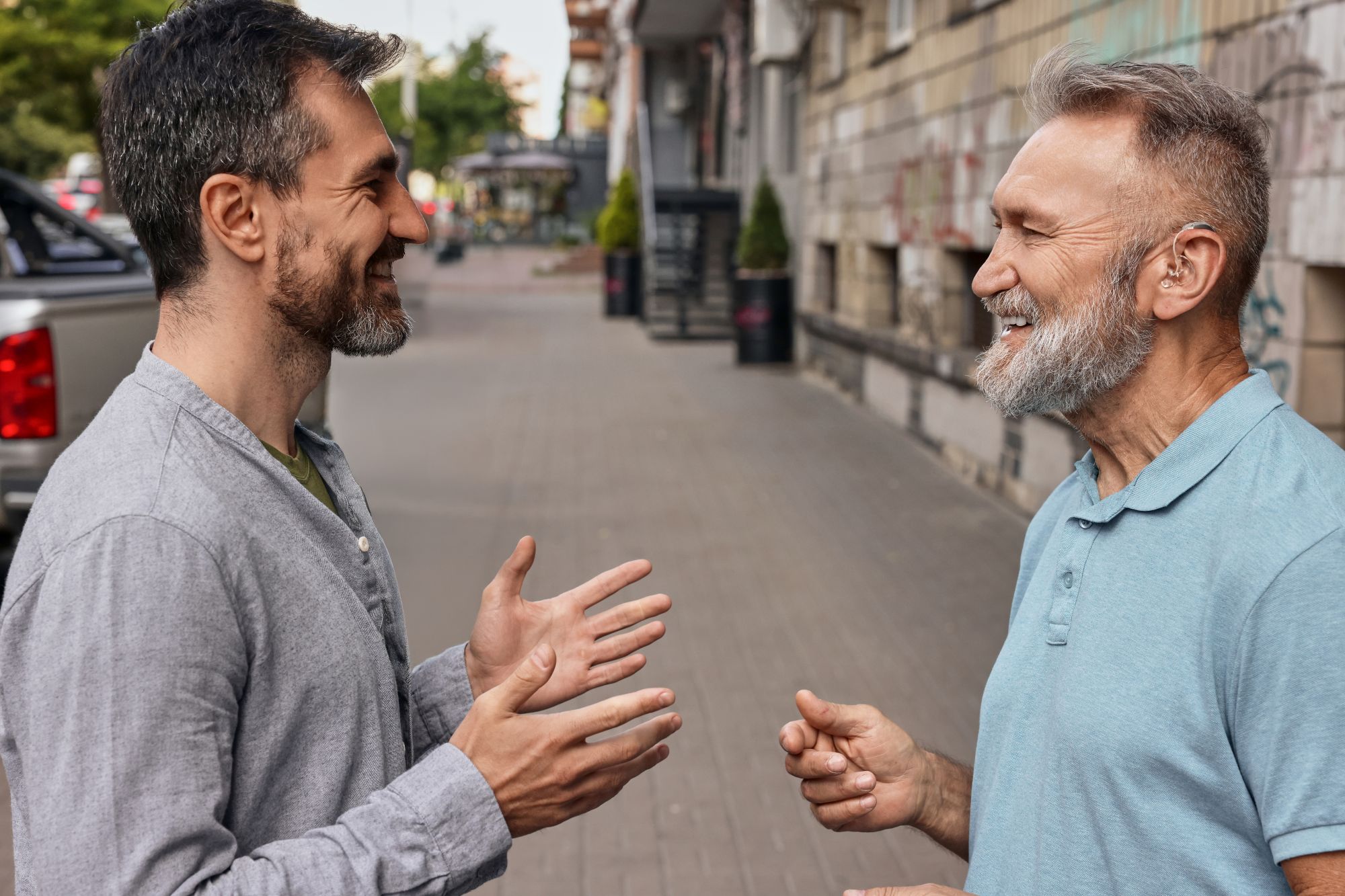 two-smiling-men-chatting-on-city-street-2026-03-25-06-08-08-utc